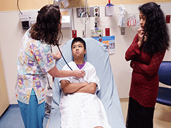 A nurse examines a patient in the Emergency Department.